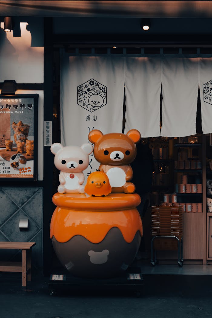 Charming bear and chick figurines atop a cauldron outside a Kyoto store.